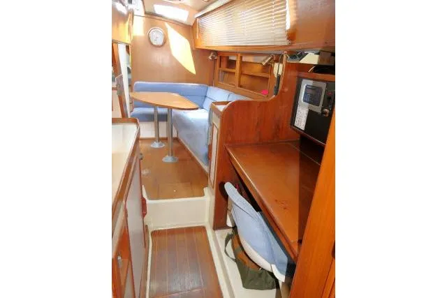 Slide: The Image of 1988 Irwin 38-2 yacht interior with wooden finish, blue seating, and navigation station. - 34