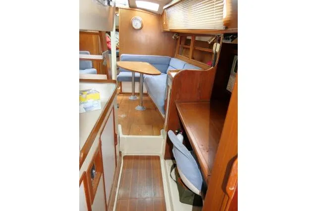 Slide: The Image of 1988 Irwin 38-2 yacht interior with wooden finish, blue seating, and compact dining area. - 35