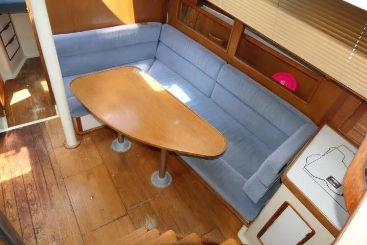 Slide: The Image of Cozy interior of 1988 Irwin 38-2 sailboat with blue seating and wooden table. - 4