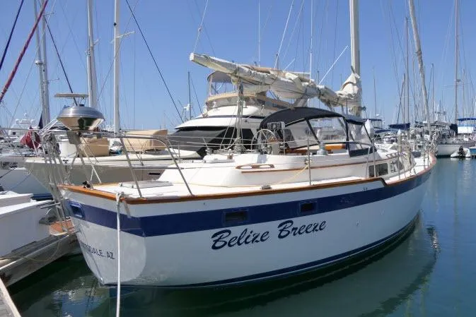 Slide: The Image of 1988 Irwin 38-2 sailboat "Belize Breeze" docked in a marina under clear blue skies. - 59