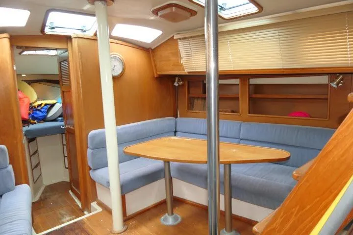 Slide: The Image of 1988 Irwin 38-2 yacht interior with wooden furnishings and blue cushioned seating. - 6
