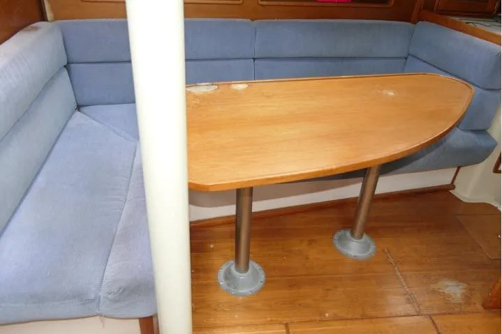 Slide: The Image of Interior of 1988 Irwin 38-2 sailboat with wooden table and blue cushioned seating. - 7