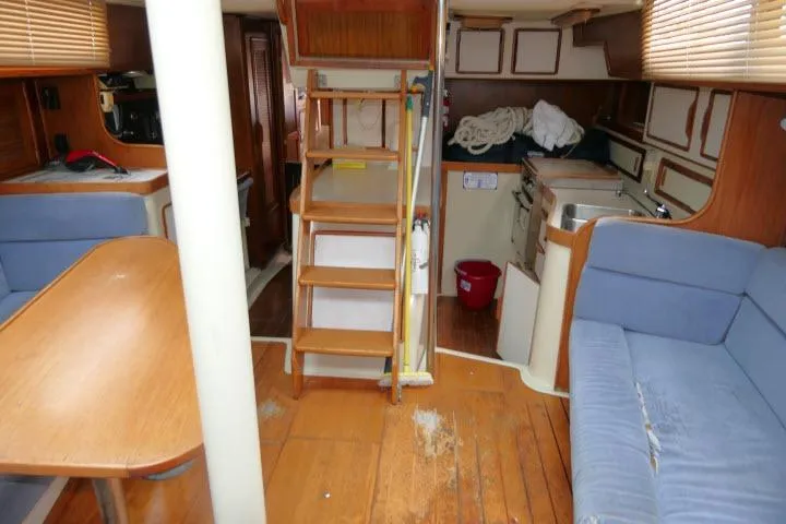 Slide: The Image of Interior of 1988 Irwin 38-2 sailboat with wooden flooring and blue seating. - 8