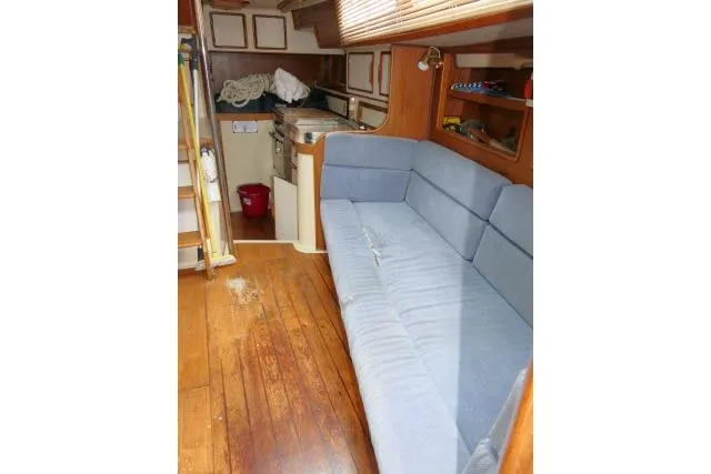 Slide: The Image of Interior of 1988 Irwin 38-2 sailboat with blue sofa and wooden flooring. - 9