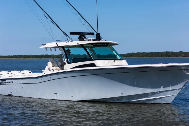 Slide: The Image of 2025 Grady-White Canyon 386 boat on calm water, clear sky background. - 11