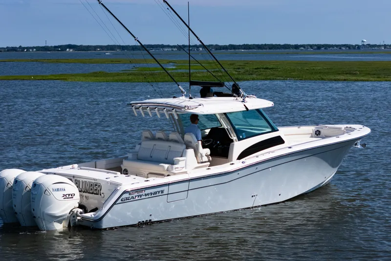 Slide: The Image of 2025 Grady-White Canyon 386 boat on water, featuring triple Yamaha engines. - 13