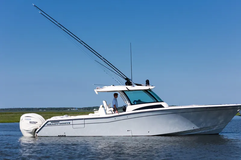 Slide: The Image of 2025 Grady-White Canyon 386 boat on calm water, side view, clear sky. - 2