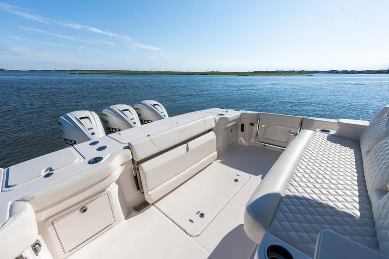 Slide: The Image of 2025 Grady-White Canyon 386 boat interior with luxurious seating and triple outboard engines. - 41