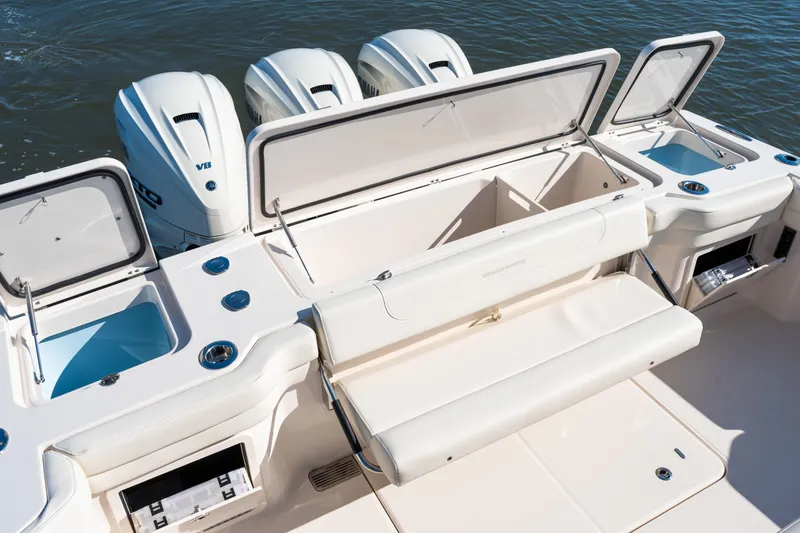 Slide: The Image of 2025 Grady-White Canyon 386 boat with open storage compartments and triple outboard engines. - 45