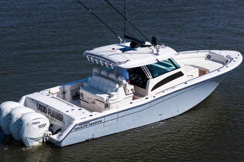 Slide: The Image of 2025 Grady-White Canyon 386 boat on water, featuring triple Yamaha engines. - 6
