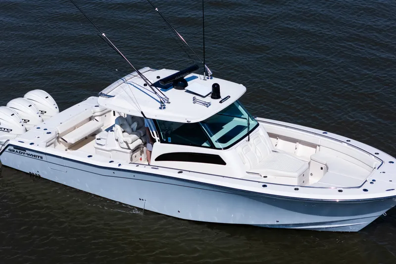 Slide: The Image of 2025 Grady-White Canyon 386 boat on water, featuring sleek design and triple engines. - 7