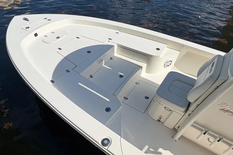 Slide: The Image of 2022 Pathfinder 2600 HPS boat interior with seating and storage, docked on water. - 13