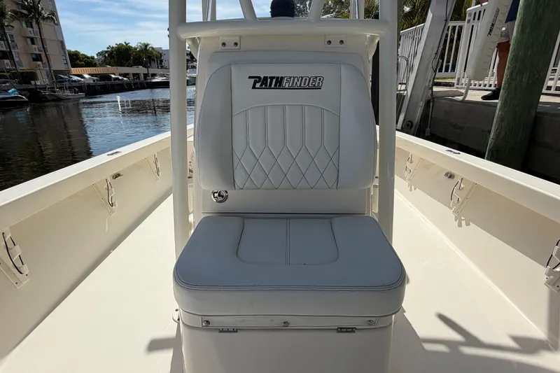 Slide: The Image of 2022 Pathfinder 2600 HPS boat seat with logo, docked by a waterfront. - 15