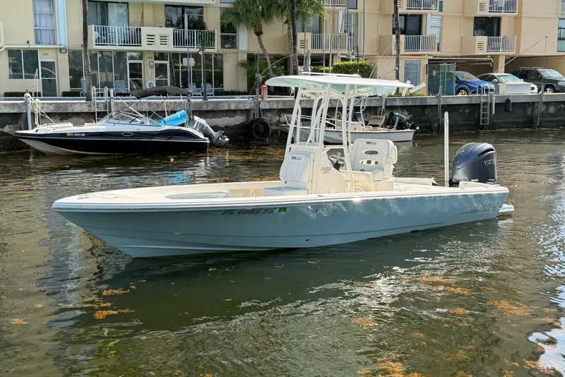 Slide: The Image of 2022 Pathfinder 2600 HPS boat docked in a marina, calm water, residential backdrop. - 2