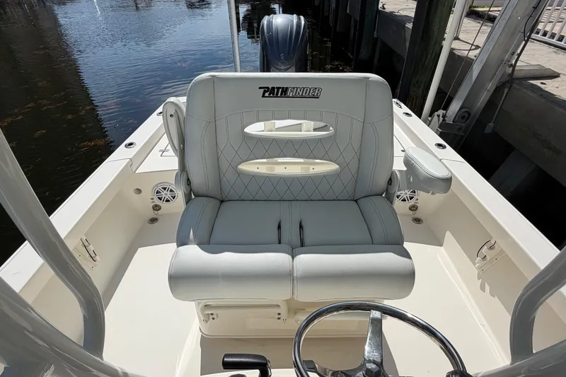 Slide: The Image of 2022 Pathfinder 2600 HPS boat interior with cushioned seating and steering wheel. - 23