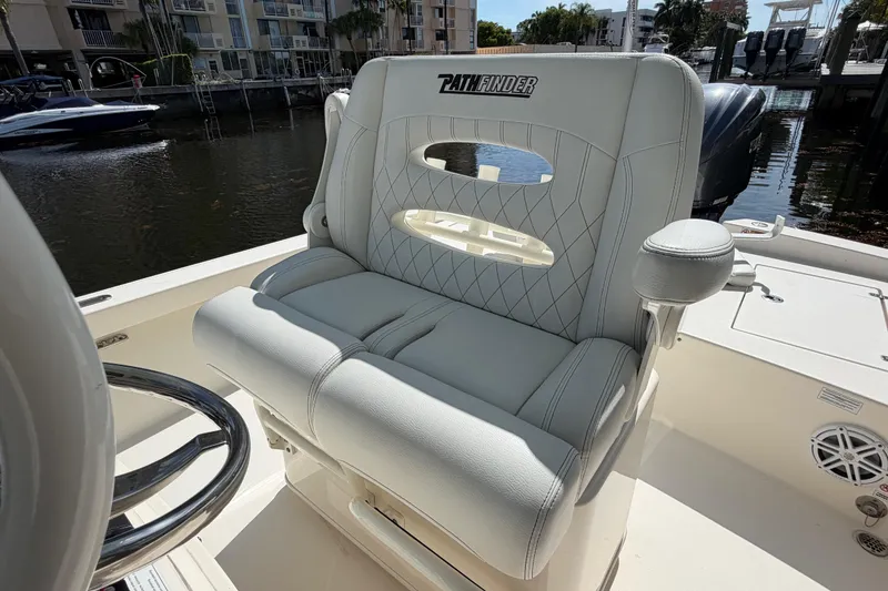 Slide: The Image of 2022 Pathfinder 2600 HPS boat seat with elegant stitching, docked near waterfront buildings. - 24
