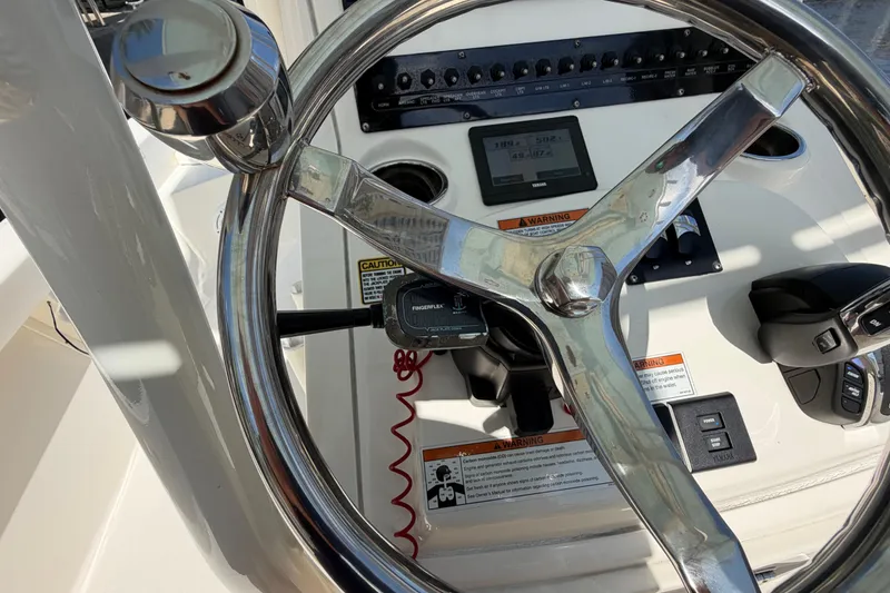 Slide: The Image of Steering wheel and controls of a 2022 Pathfinder 2600 HPS boat cockpit. - 31