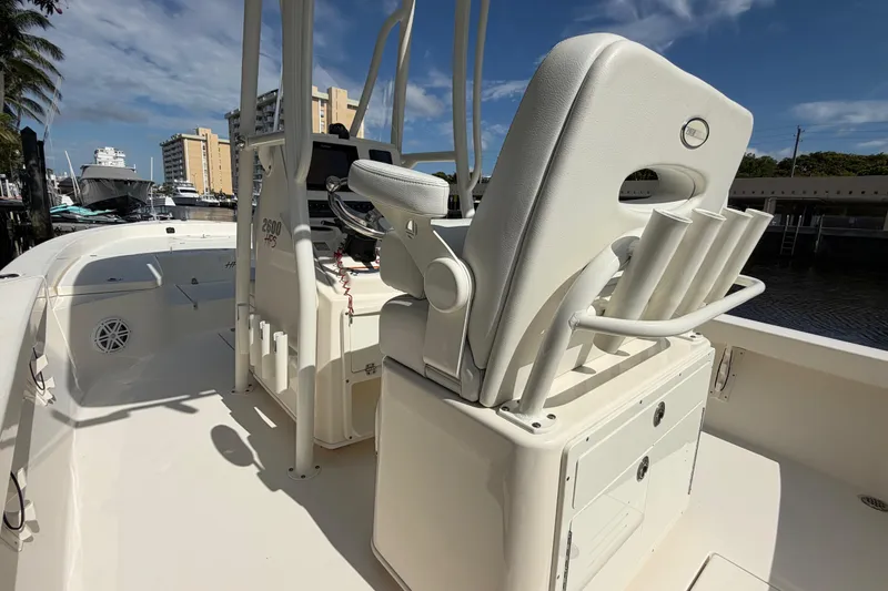 Slide: The Image of 2022 Pathfinder 2600 HPS boat interior with helm seat and rod holders, docked under clear skies. - 37