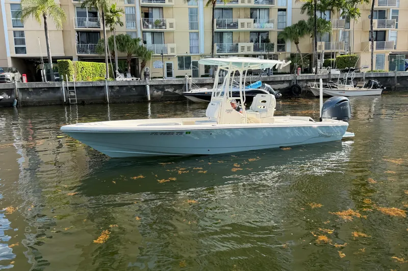Slide: The Image of 2022 Pathfinder 2600 HPS boat docked in a canal near waterfront apartments. - 4