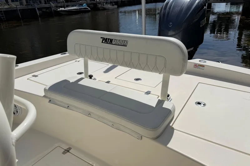 Slide: The Image of 2022 Pathfinder 2600 HPS boat interior with cushioned seating and motor view. - 42