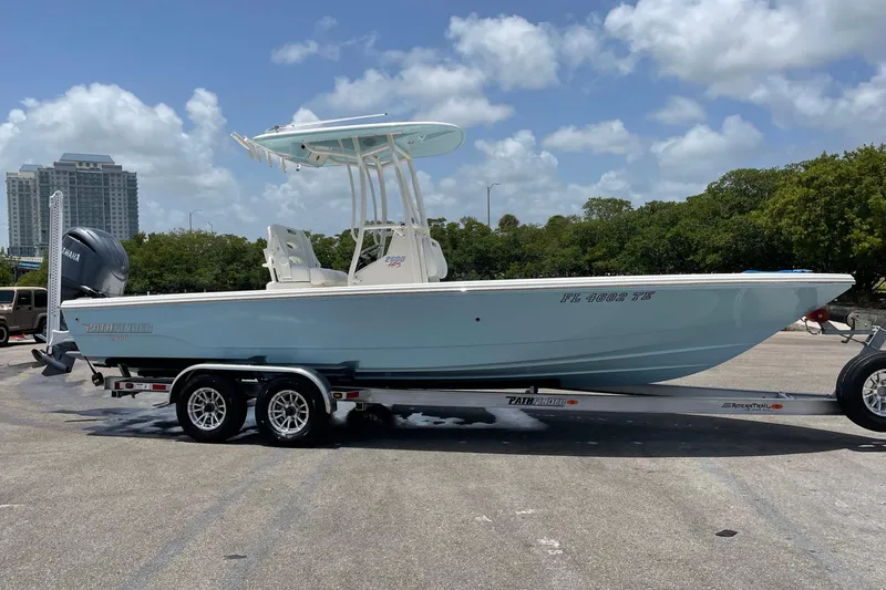 Slide: The Image of 2022 Pathfinder 2600 HPS boat on trailer, parked outdoors under a clear sky. - 8