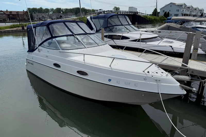 The Image of 1998 Four Winns 258 Vista boat docked in a marina, featuring a sleek white design. - 0
