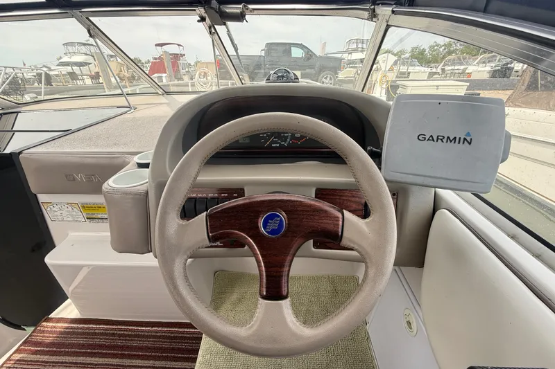 Slide: The Image of 1998 Four Winns 258 Vista boat helm with Garmin GPS and wood-accented steering wheel. - 13
