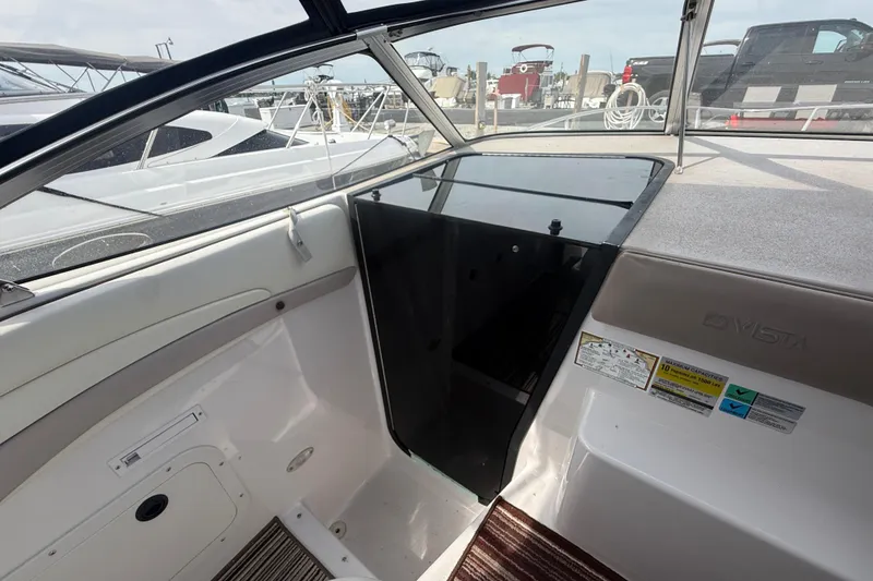 Slide: The Image of 1998 Four Winns 258 Vista boat interior with cabin entrance and docked boats in background. - 17