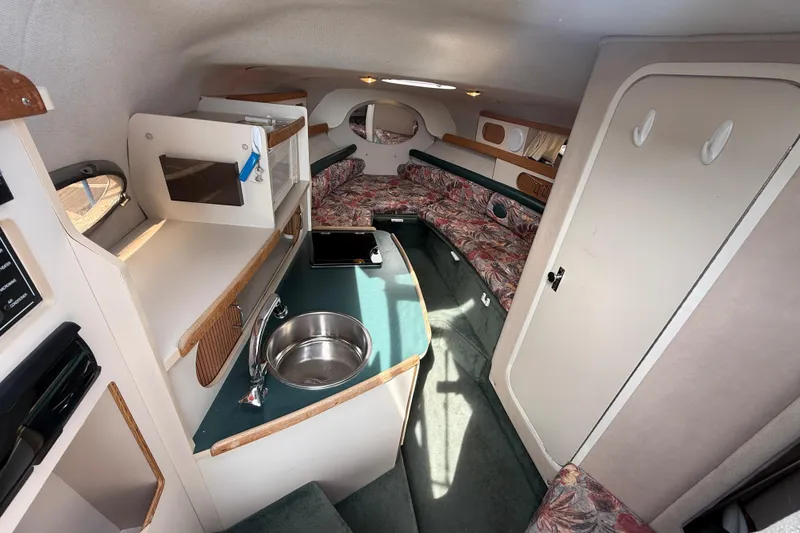Slide: The Image of Interior of 1998 Four Winns 258 Vista boat with kitchenette and seating area. - 18