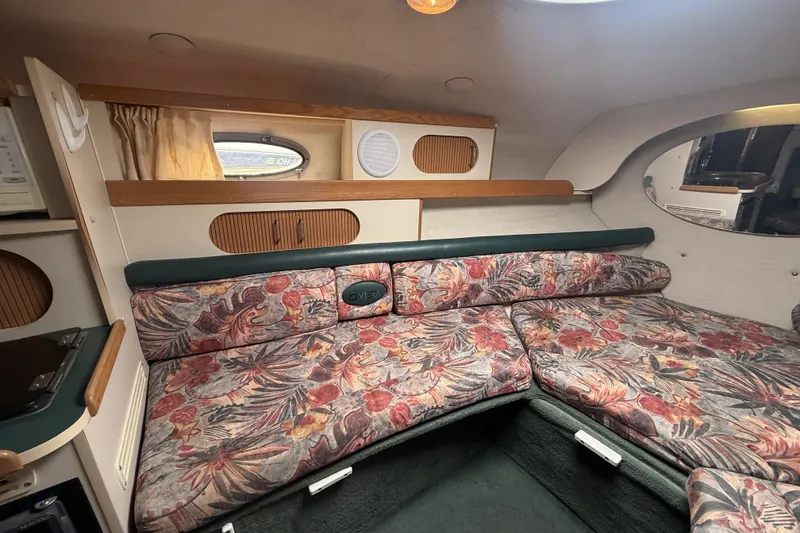 Slide: The Image of 1998 Four Winns 258 Vista cabin interior with floral upholstery and compact design. - 20