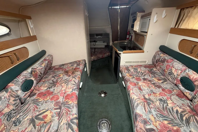Slide: The Image of Interior of a 1998 Four Winns 258 Vista boat with floral upholstery and compact kitchen area. - 22
