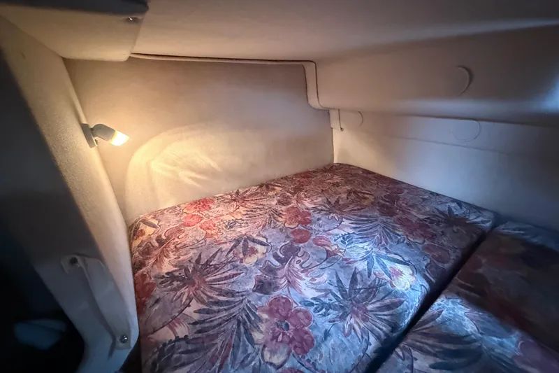 Slide: The Image of Cozy cabin interior of 1998 Four Winns 258 Vista boat with floral bedding and soft lighting. - 26