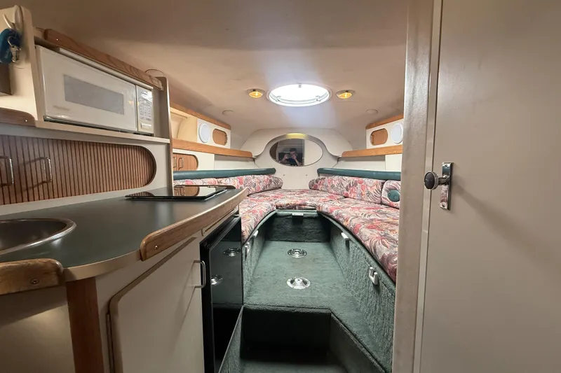 Slide: The Image of Interior of 1998 Four Winns 258 Vista boat with kitchenette and cozy seating area. - 27