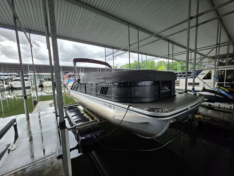 Slide: The Image of 2022 Bennington 25LSB pontoon boat docked under shelter. - 13