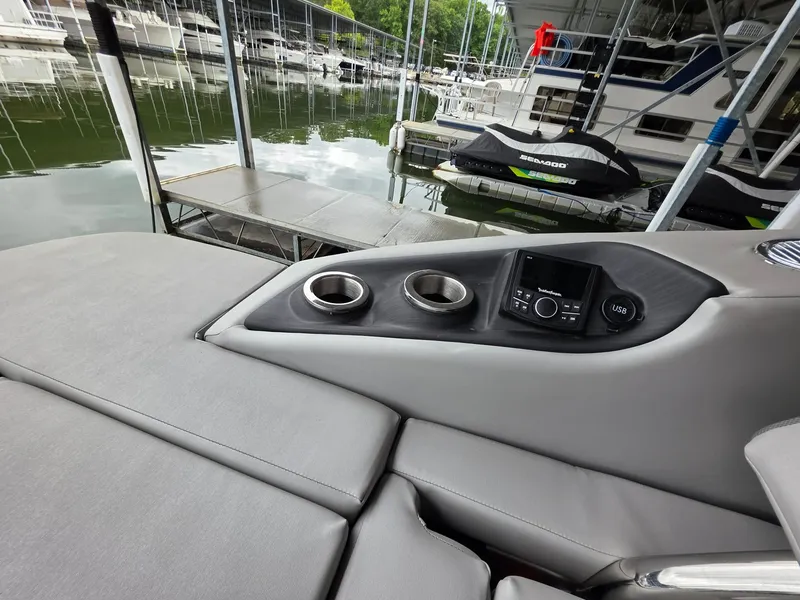 Slide: The Image of Bennington 25LSB 2022 with gray upholstery and cup holders at the dock. - 26