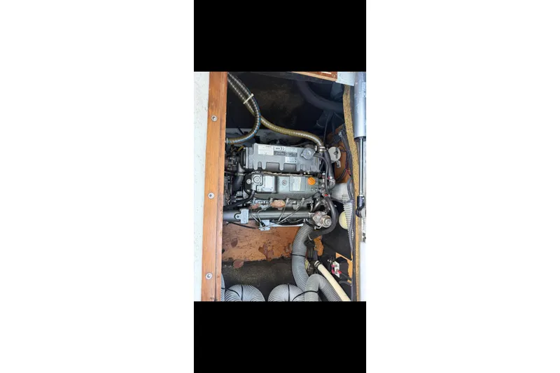 The Image of Engine compartment of a 2010 Lagoon 421 catamaran, showcasing mechanical components and hoses. - 1