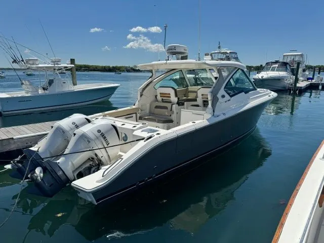 Slide: The Image of 2021 Pursuit 326 DC boat docked on water. - 13