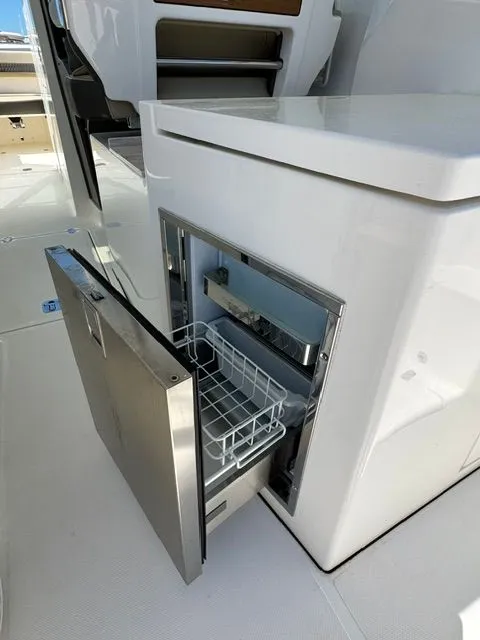 Slide: The Image of Open refrigerator on a 2021 Pursuit 326 DC boat. - 18