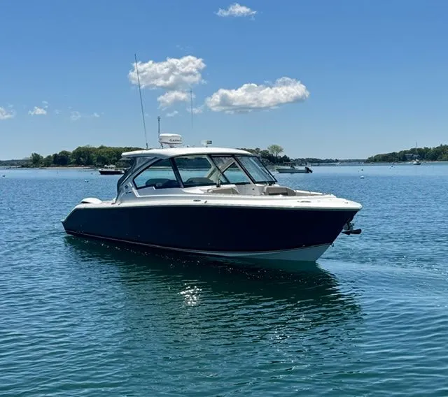 Slide: The Image of 2021 Pursuit 326 DC boat on calm water. - 2