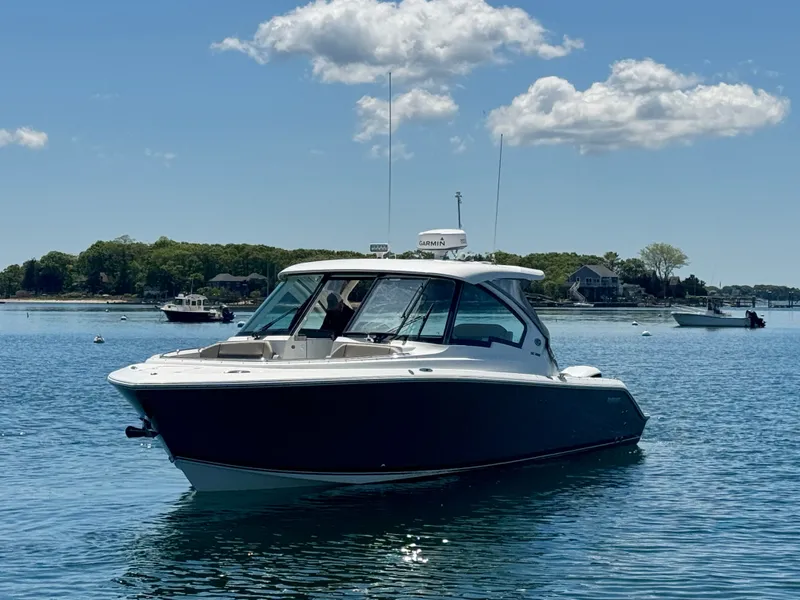Slide: The Image of 2021 Pursuit 326 DC boat on calm water under sunny sky. - 4