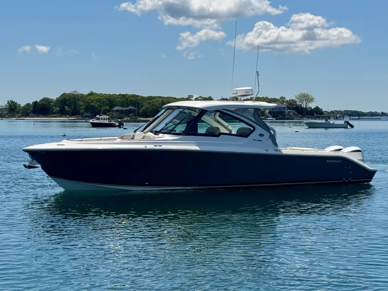 Slide: The Image of 2021 Pursuit 326 DC boat on calm water. - 7