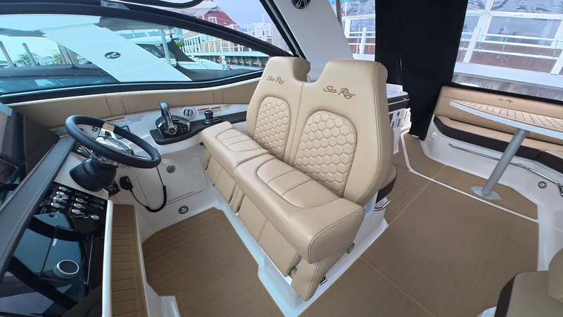 Slide: The Image of Interior of the Sea Ray Sundancer 320 Outboard with sleek beige seating and modern helm. - 18