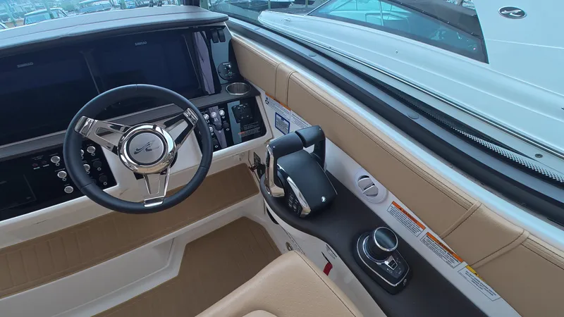 Slide: The Image of The cockpit of the 2025 Sea Ray Sundancer 320 Outboard features a modern steering wheel and controls. - 22