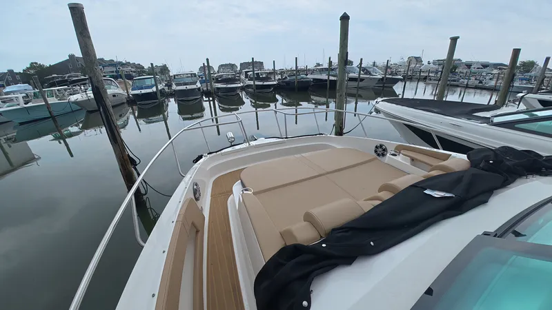 Slide: The Image of A 2025 Sea Ray Sundancer 320 Outboard is docked in a calm marina, surrounded by other boats. - 27