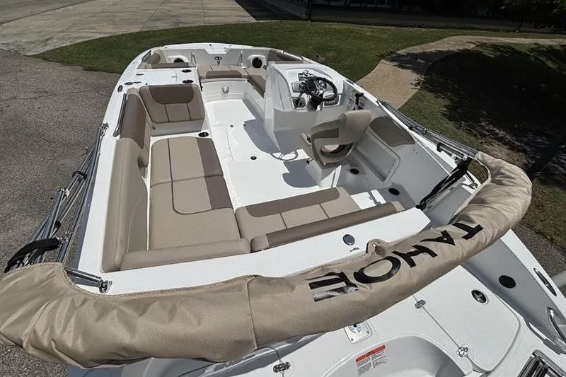 Slide: The Image of 2026 Tahoe 2150 boat interior with beige seating and steering console. - 10