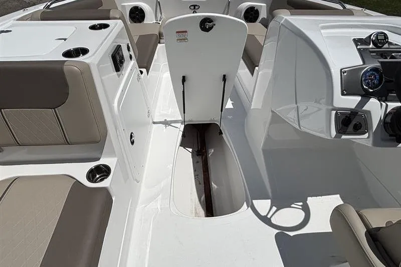 Slide: The Image of 2026 Tahoe 2150 boat interior with open storage compartment and beige seating. - 11