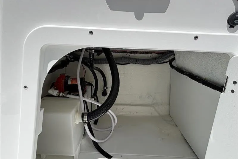 Slide: The Image of 2026 Tahoe 2150 boat compartment with hoses and wiring, showcasing interior details. - 14