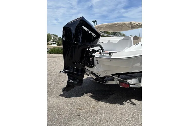 Slide: The Image of 2026 Tahoe 2150 boat with Mercury outboard motor, parked on a trailer. - 16
