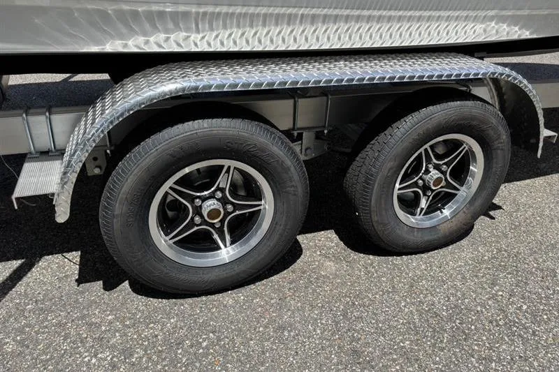 Slide: The Image of 2026 Tahoe 2150 trailer with dual wheels and metallic fender on asphalt. - 17