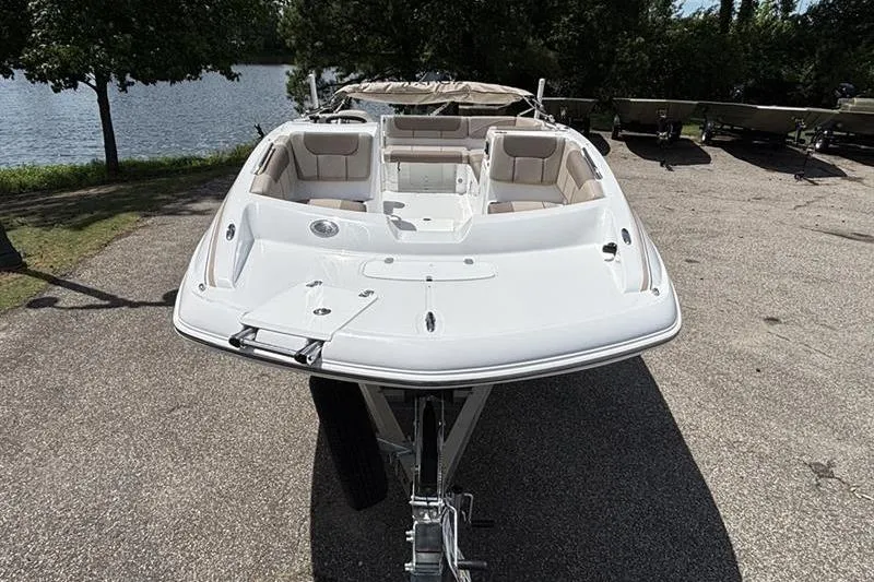 Slide: The Image of 2026 Tahoe 2150 boat on trailer by a lakeside, showcasing sleek design and spacious seating. - 4